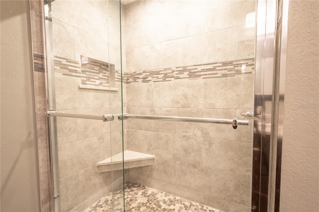Bathroom 2 continues the theme of elegance with its artistic tile walk-in shower.