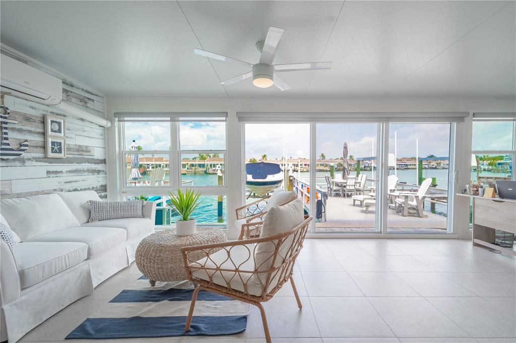 he enclosed Florida room, with its expansive water views, triple pane sliding glass doors, and charming shiplap accent walls.