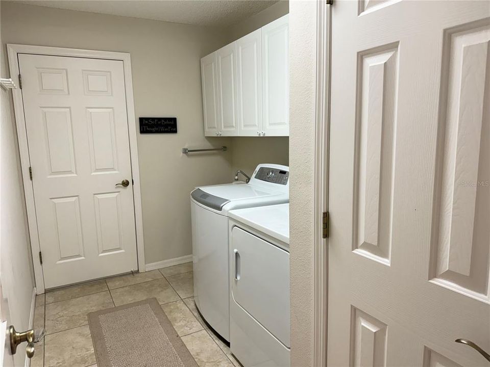 Laundry room w/ Solar tube and cabinets above W&D