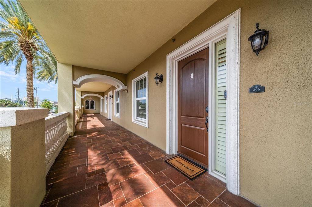 Arched, wide covered walkway and architectural details enhance the private entry.