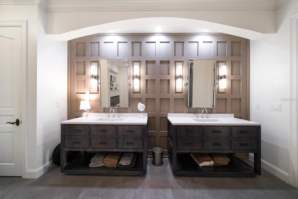 Double vanities enhanced by stunning wall treatment.