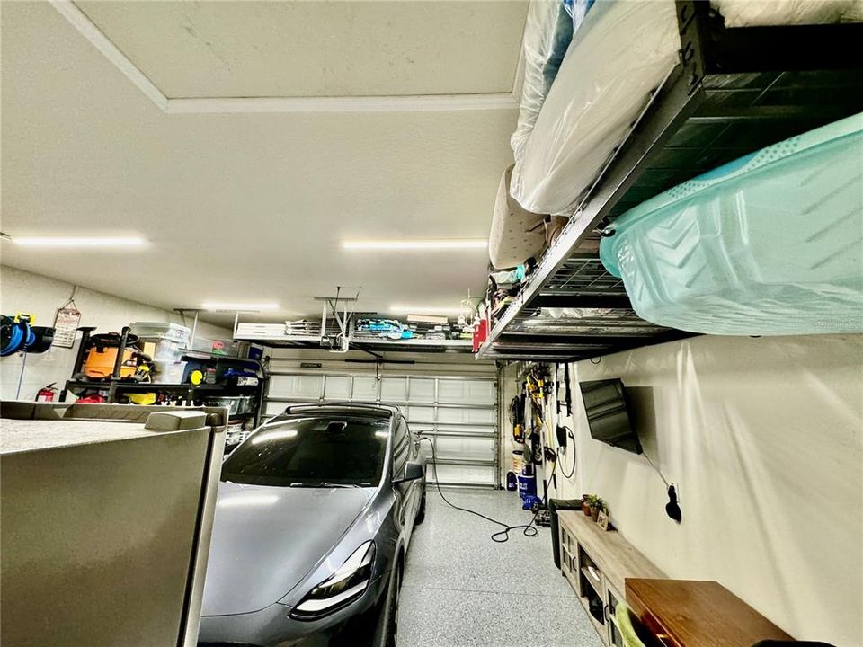 Garage is enlarged and includes many overhead racks for storage.