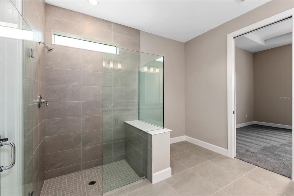 A spacious walk-in shower and pocket door to the primary bedroom.