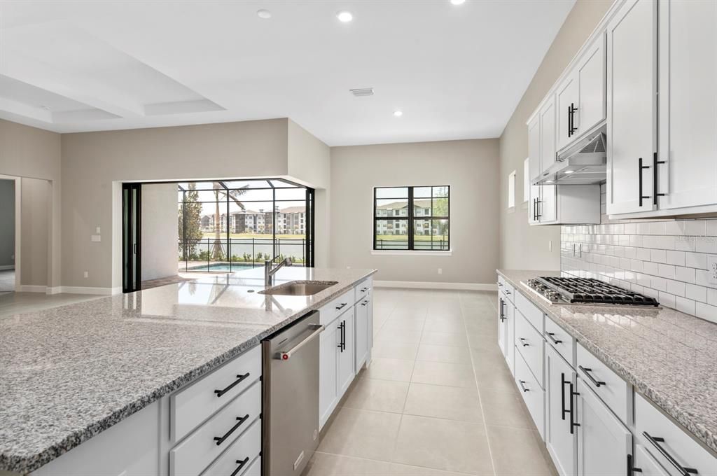 Pretty views from the kitchen with its granite counters, built-in gas range and clean white cabinetry.