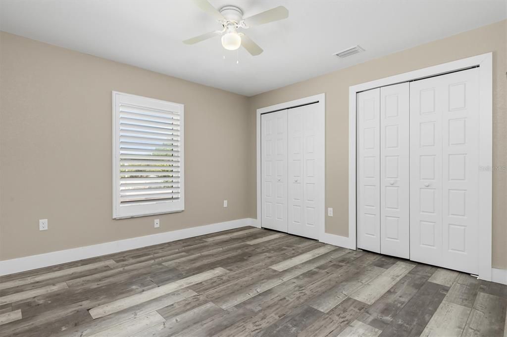 Bedroom on right side has connecting large closet and plantation shutters.