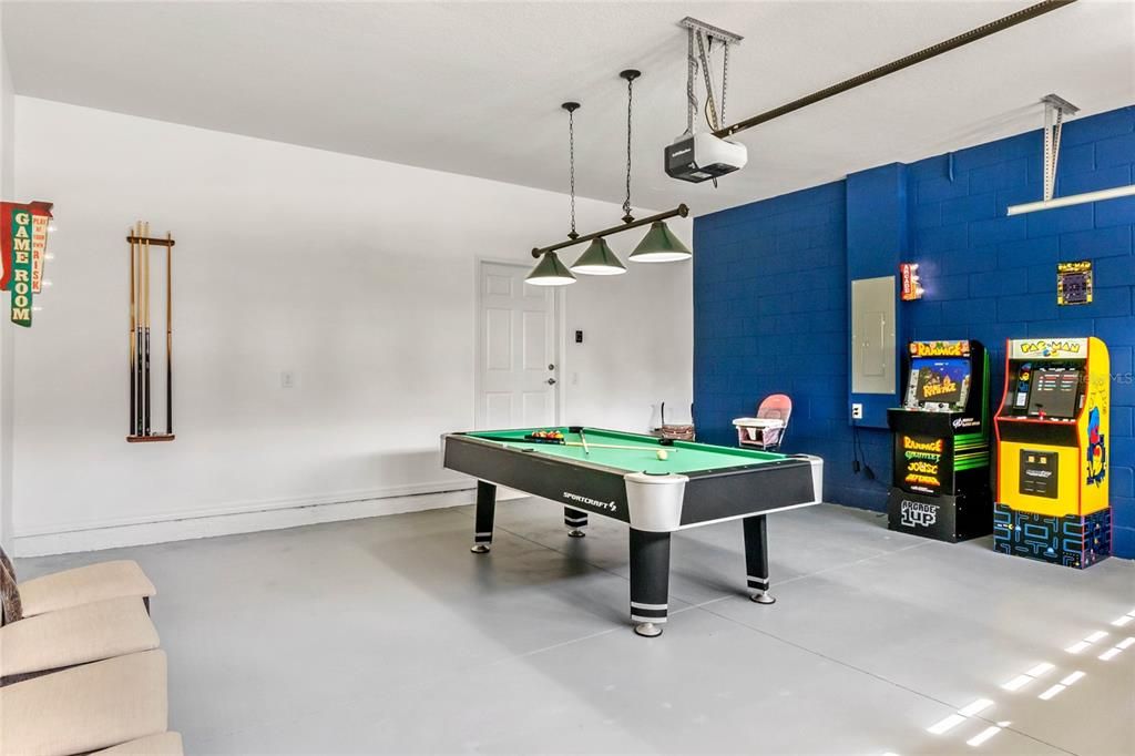 large garage converted to game room with pool table and arcade games