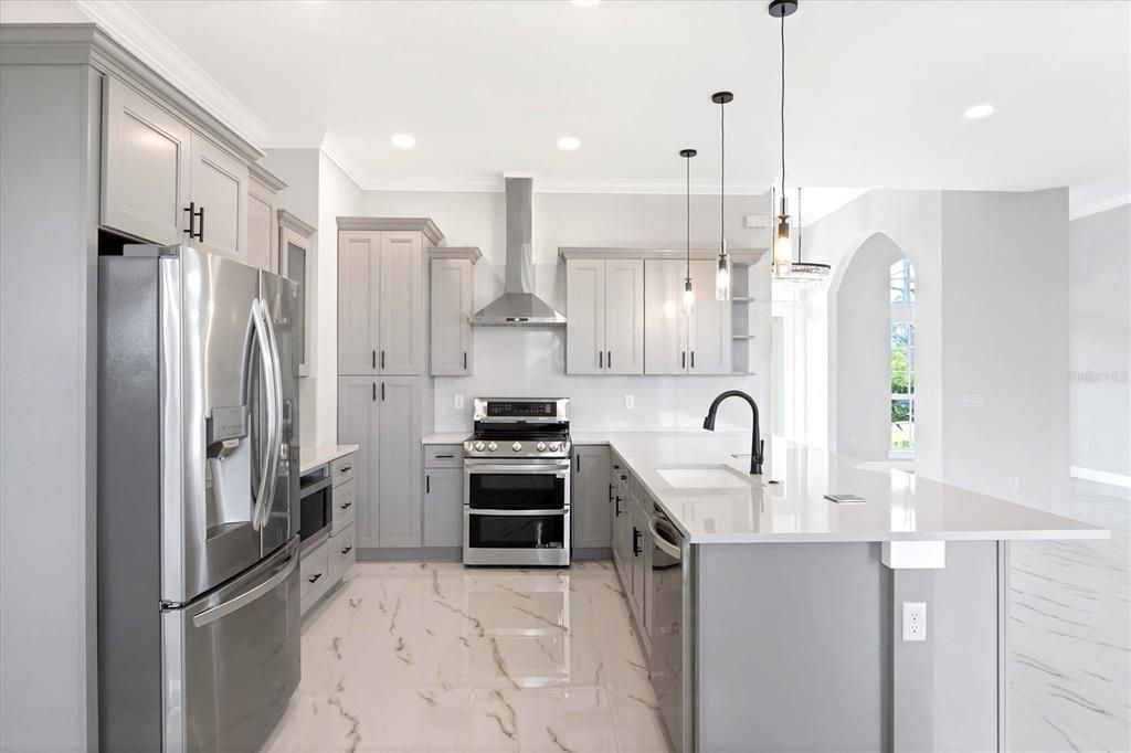 Stainless appliances and Quartz counters highlight the open kitchen