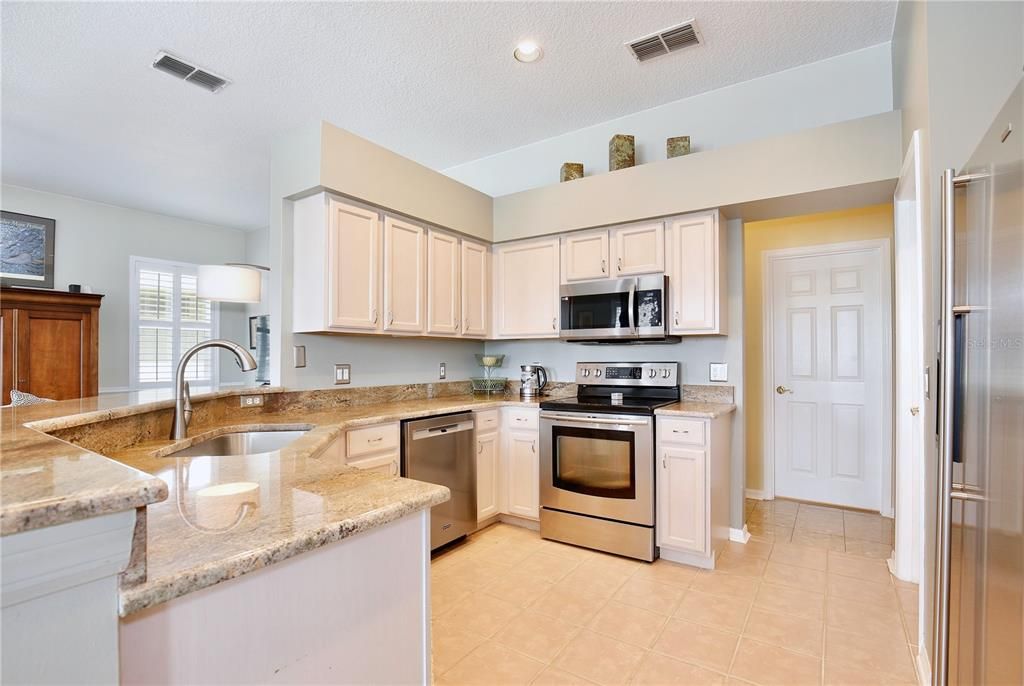 Kitchen is adjacent and open to Family Room. granite counter, stainless steel appliances, tile floor.