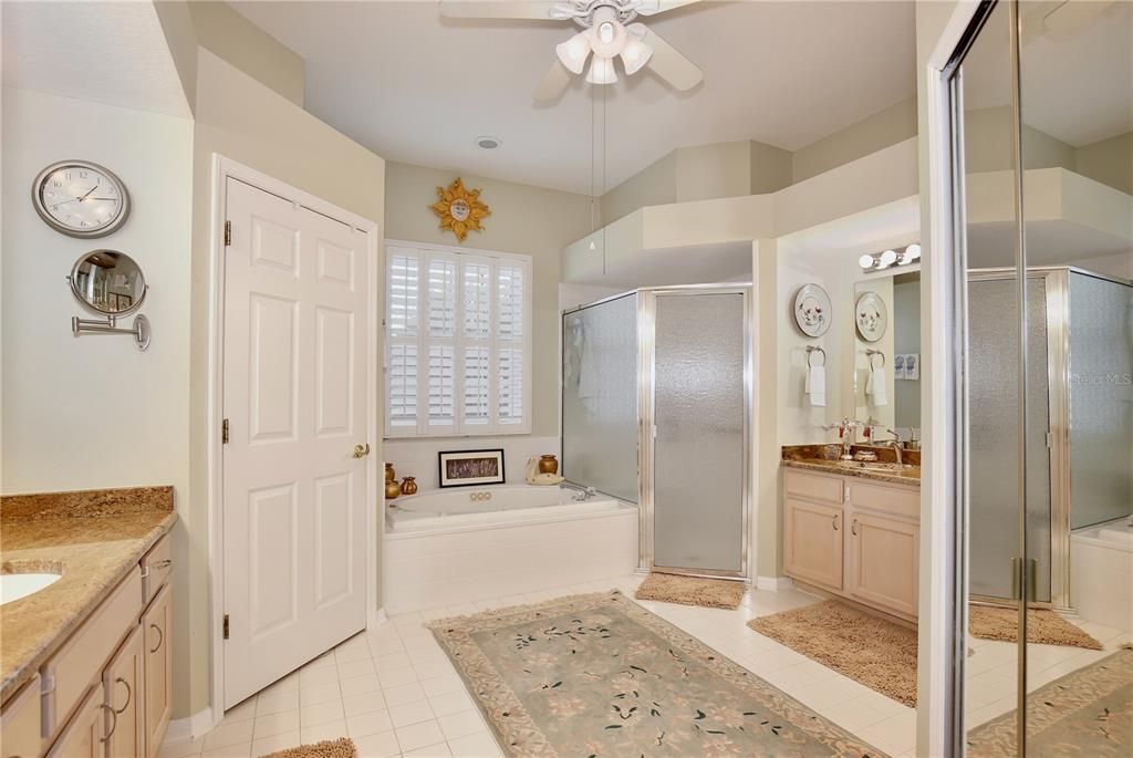 Spacious Owner Suite Bathroom  Two separate vanities with cabinets, private bathroom, Jacuzzi Jet bath tub, extra large shower with seat and shelves and Large walk in closet and Ceiling fan.  Custom Plantation shutters,