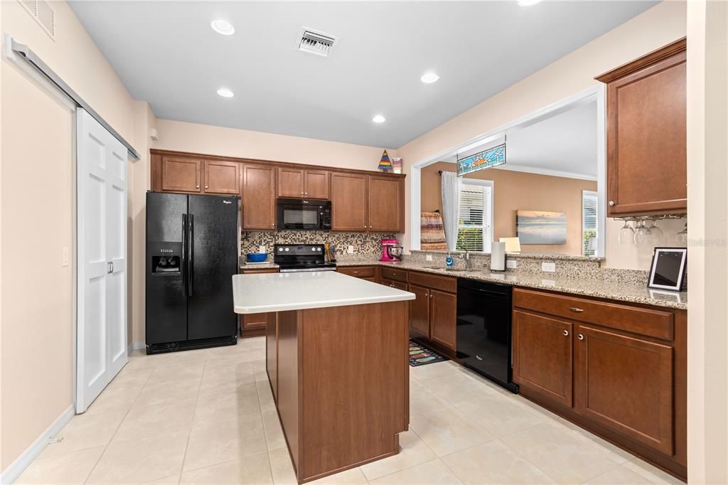 KITCHEN WITH QUARTZ ISLAND, WOOD CABINETS AND ALL APPLIANCE STAY