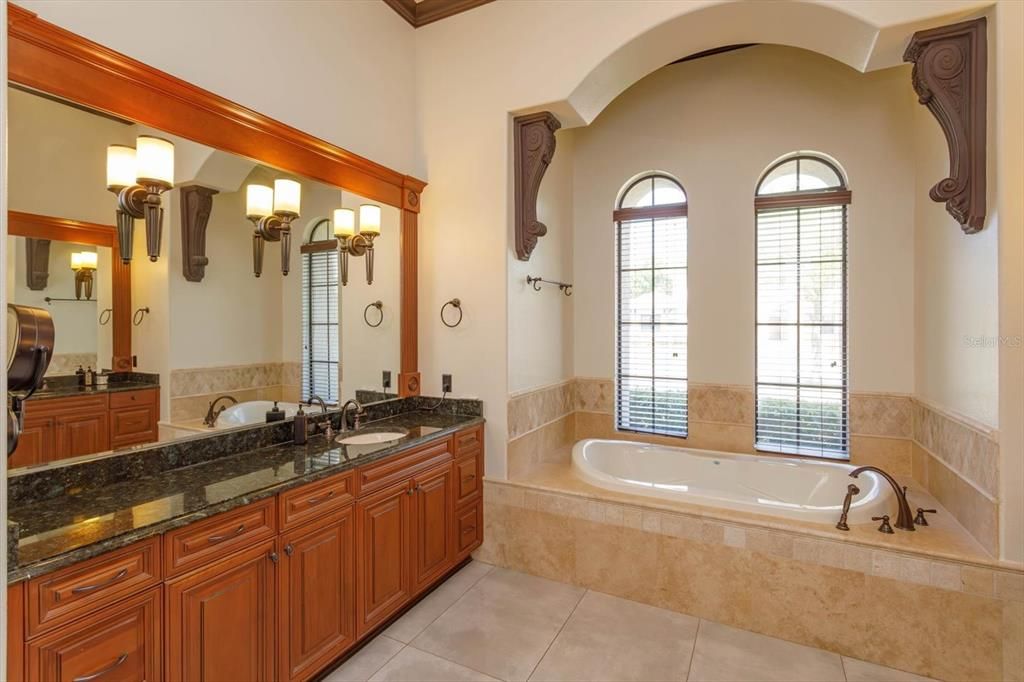 Primary bathroom with two granite vanities, jetted tub