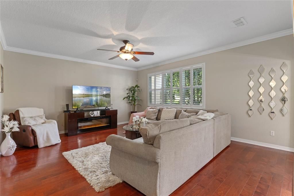 Family Room offers more hardwood floors, crown molding and plantation shutters. Located just off the kitchen.