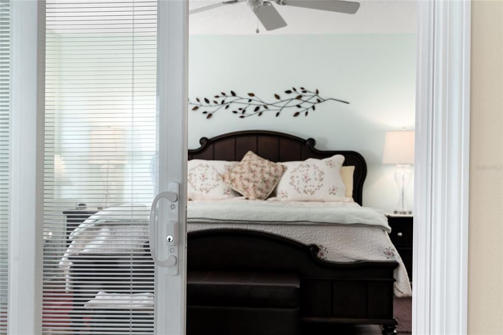 SLIDING GLASS DOORS w/ BUILT-IN BLINDS give alternative access to PRIMARY BEDROOM.