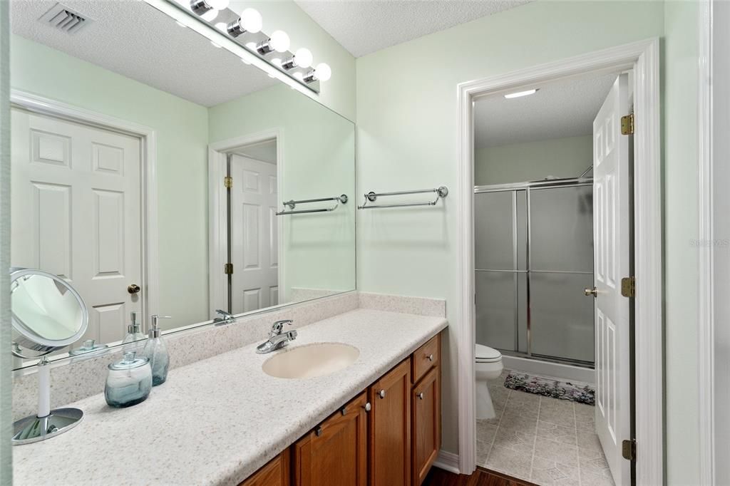 ENSUITE BATHROOM with CLOSET across hallway & reflected in mirror.