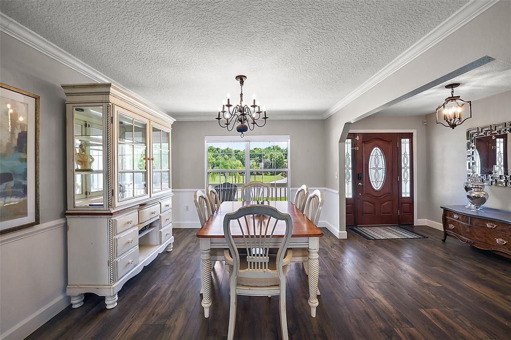 Dining room with crown molding, wainscoting, chair rail and decorative niche