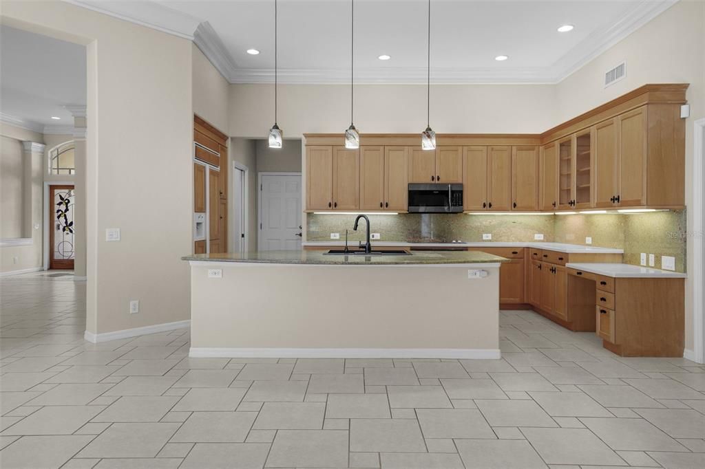 View from family room to kitchen with foyer beyond