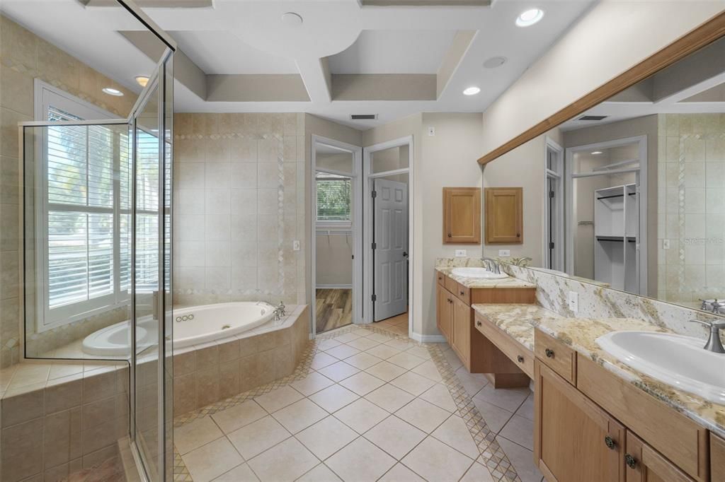 Master bathroom looking toward private lavatory and large walk-in master closet with built-in shelving.