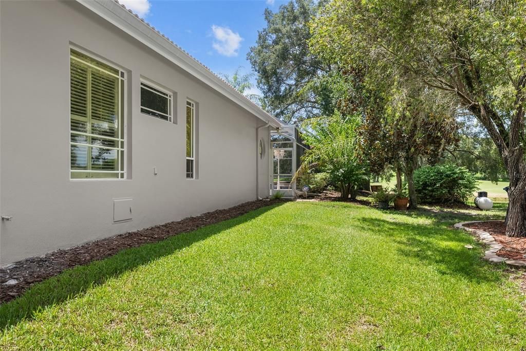 South side of home looking toward golf course and beautiful tree-lined backyard.  NEWLY PAINTED NEUTRAL EXTERIOR July 2024!