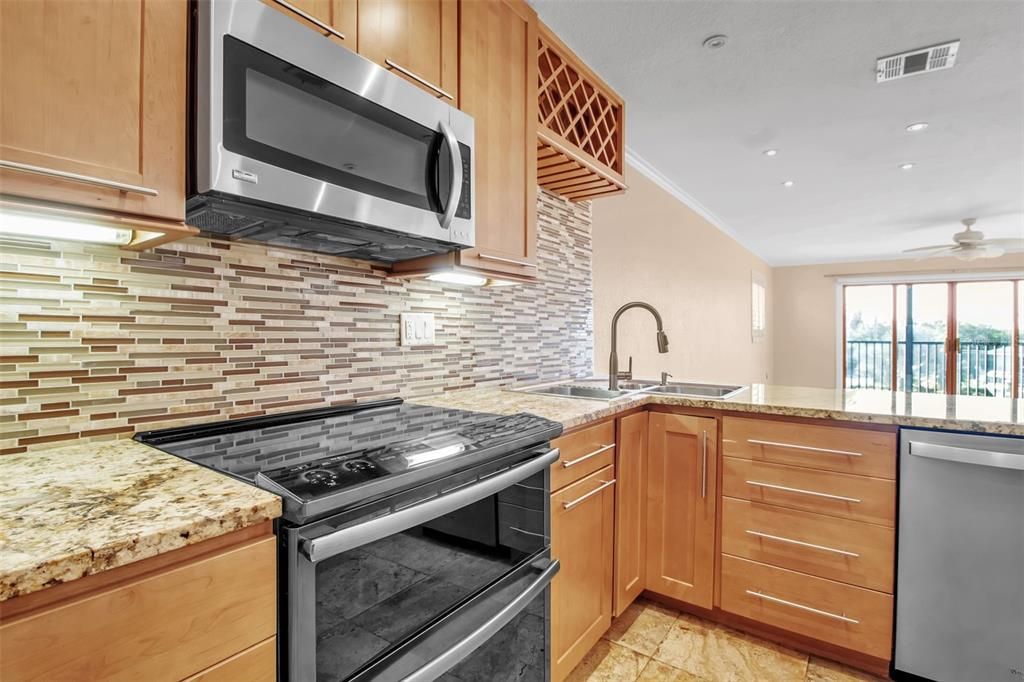 Kitchen with Granite counters, glass back splash, stainless steel appliances and soft close drawers and cabinets
