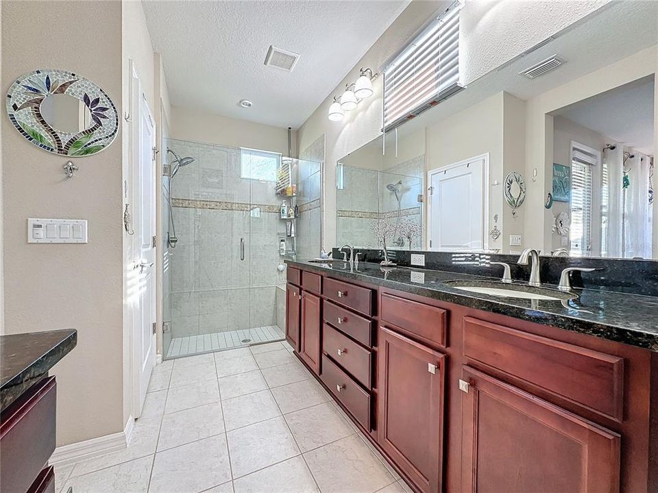 PRIVATE PRIMARY BATHROOM with FRAMELESS SHOWER DOOR and BENCH, a COMFORT-HEIGHT TOILET, LARGE WALK-IN CLOSET plus a LINEN CLOSET