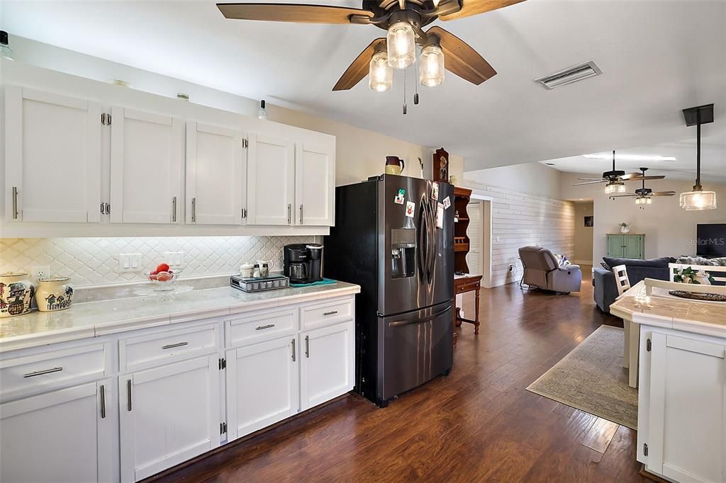 Kitchen has light below and above the cabinets.