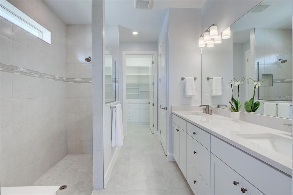 Owner's bathroom with dual sinks and walk in shower