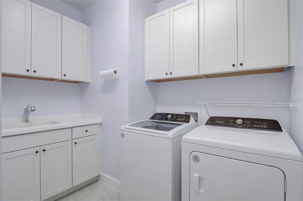 Laundry room with upgraded cabinetry and washtub