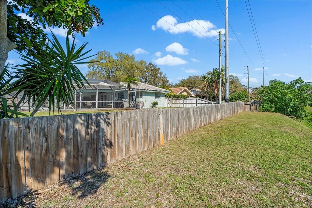 First 10-12 ft outside the fence is your land.  You can leave open as is or allow vegetation growth for additional privacy.  As the slope begins it becomes Pinellas County controlled area.