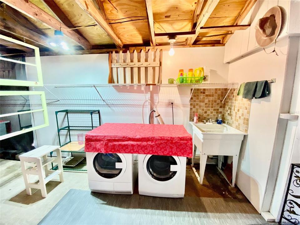 Laundry in garage w wash sink and adjacent shower/commode
