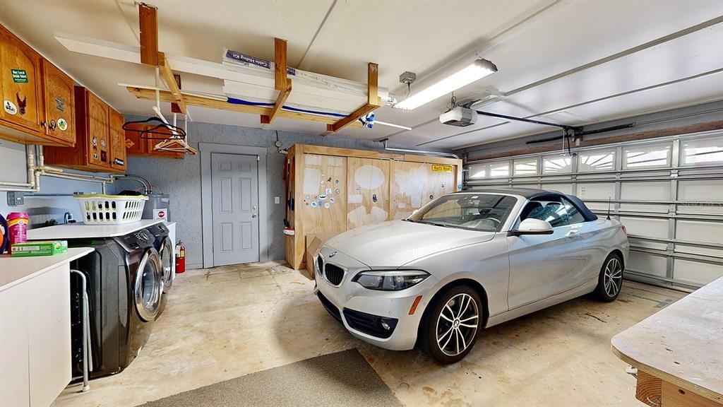 two-car attached garage with storage and an extra refrigerator