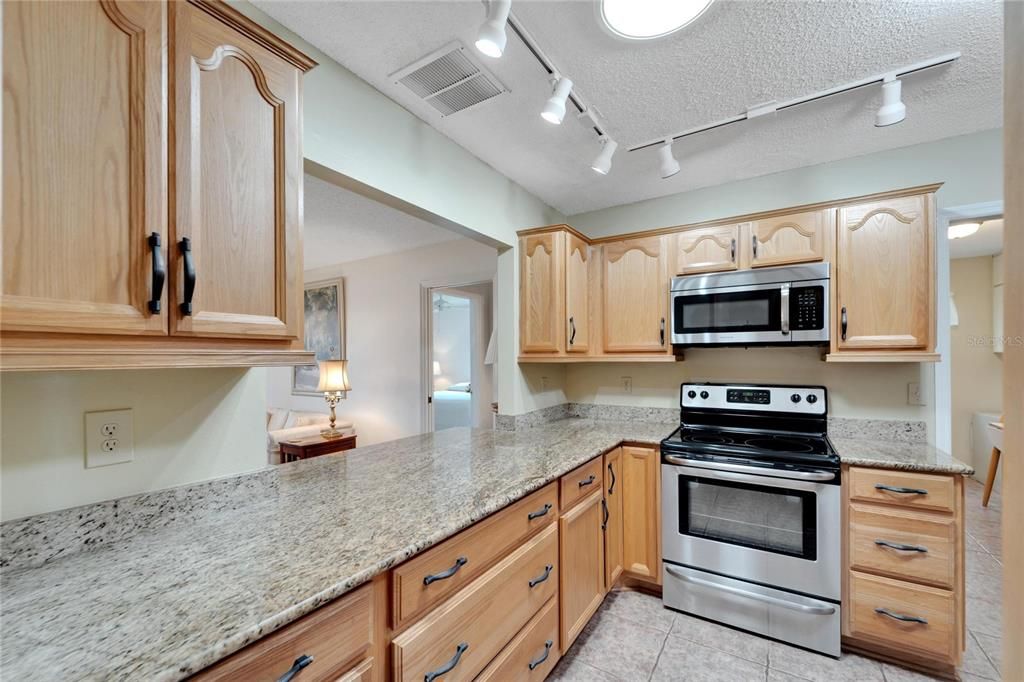 As you enter the kitchen from the dining room area, Note the beautiful GRANITE counters and raised panel wood cabinets. Note the SKYLIGHT above that provides abundant light