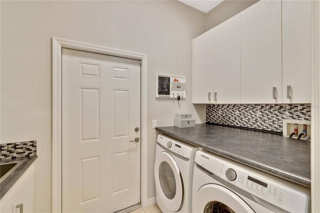 Really nice Laundry Room..... Check out the built-in countertop over the front load washer and dryer.....how about that backsplash....