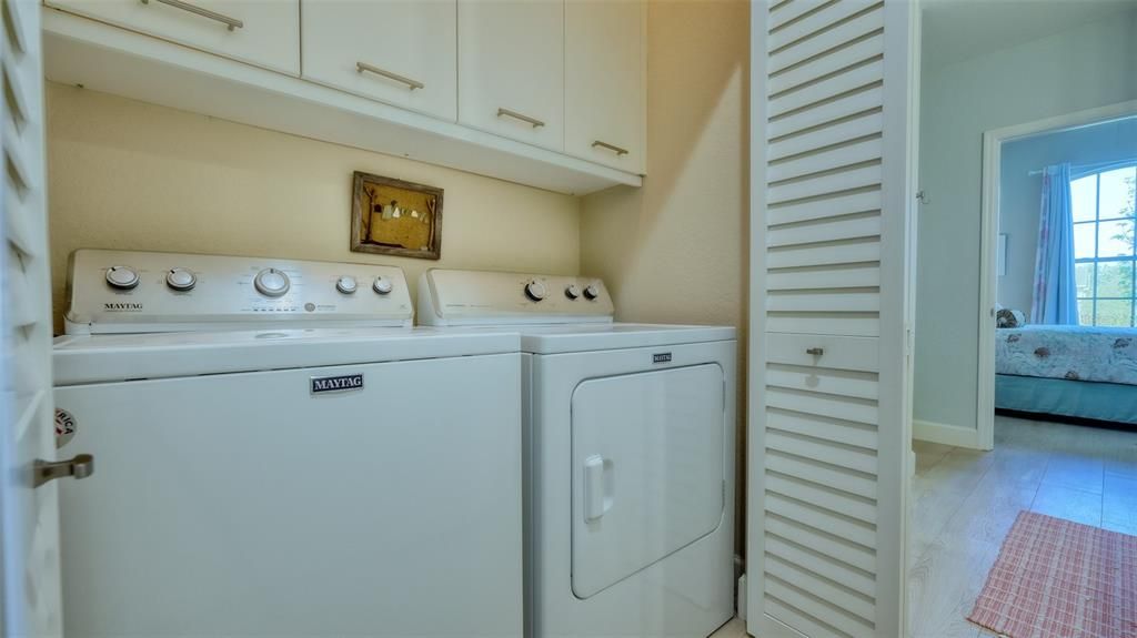 Laundry with cabinets for extra storage.