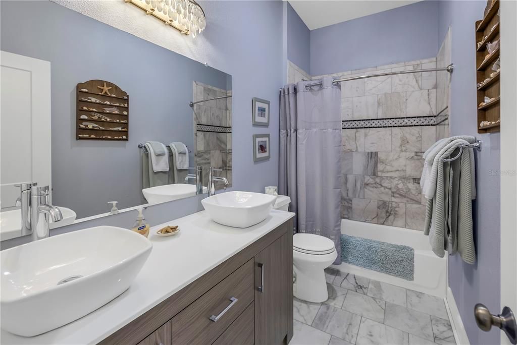 Full guest bathroom featuring dual sinks.