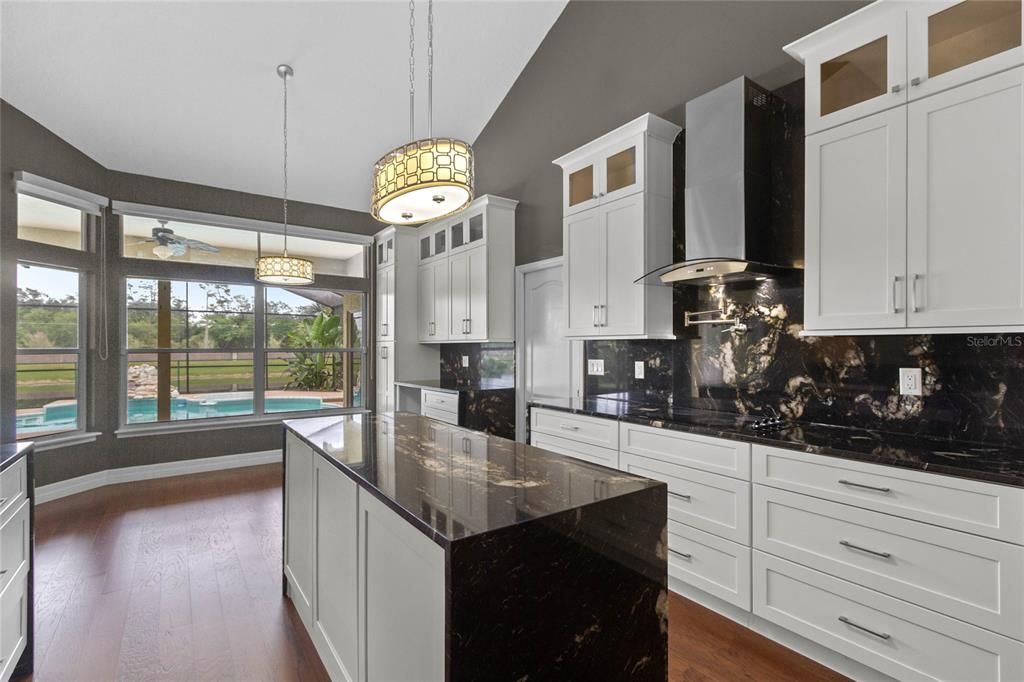 The kitchen features an expansive center island with built in microwave and waterfall granite counter tops.