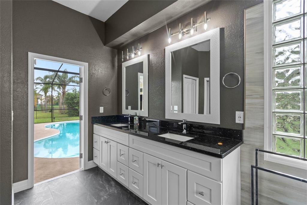 The master bathroom features, pool door access and a double vanity.