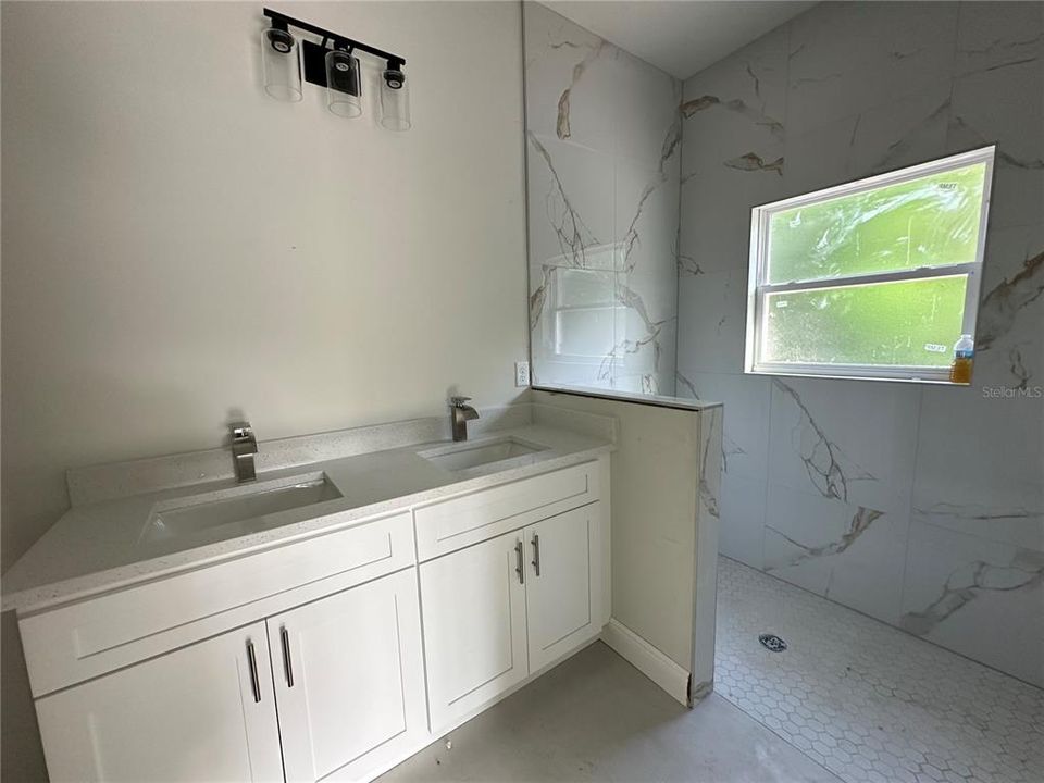 Primary bath with double sinks and walk-in tiled shower