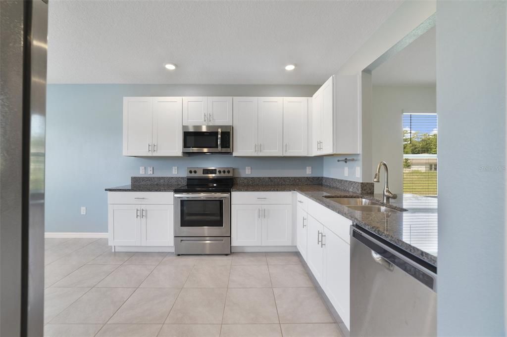 Start your tour in the modern kitchen where you will be delighted to find SHAKER STYLE CABINETS, STAINLESS STEEL APPLIANCES, granite counters and a dining area in front of bay windows for exceptional NATURAL LIGHT!