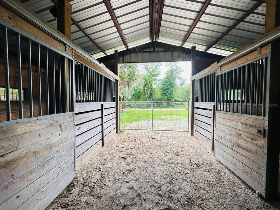 Center aisle of barn showing 4 stalls.
