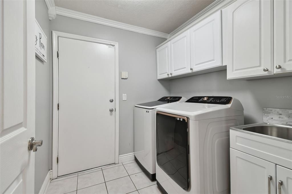 laundry room complete with cabinets and utility sink