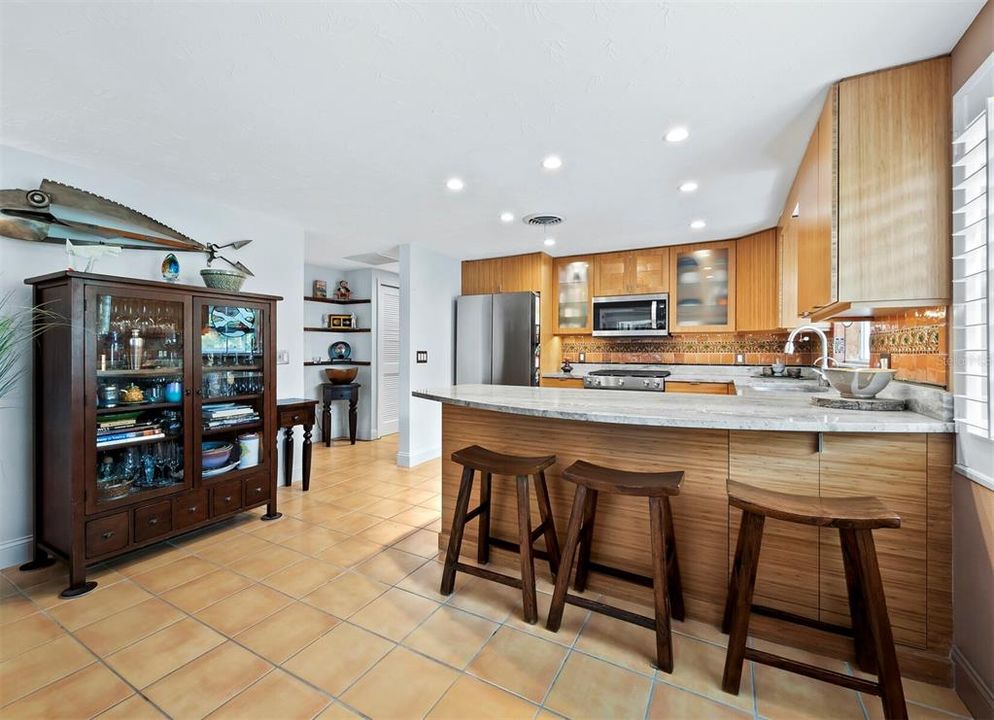 The kitchen includes a breakfast bar, bamboo cabinetry, 2023 appliances and a chefs gas range