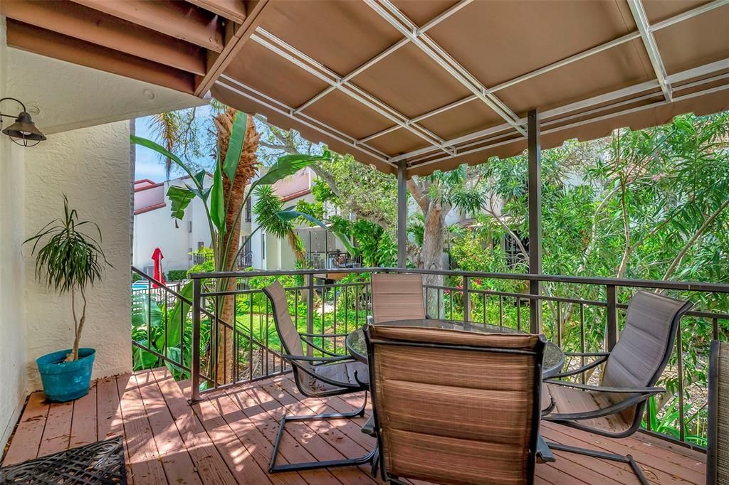 The balcony from the living room area looks out to the luscious garden area and the pool to the left.