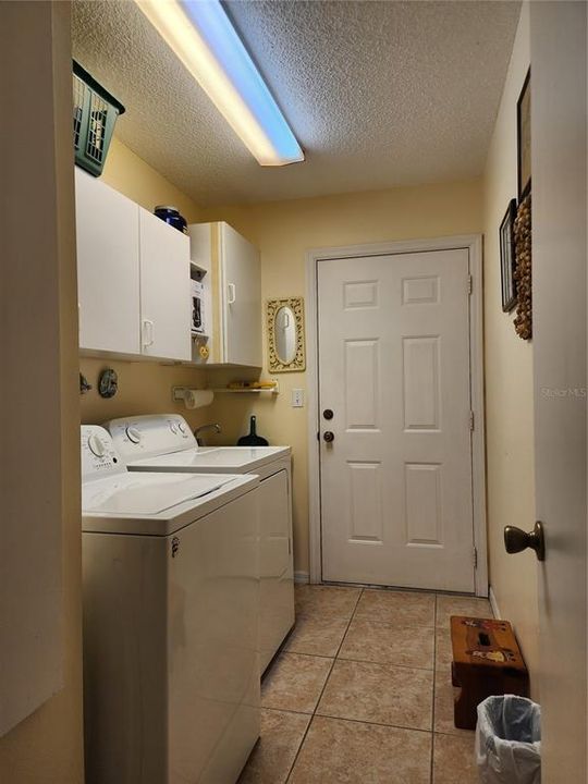Inside Laundry room with cabinets above and laundry sink