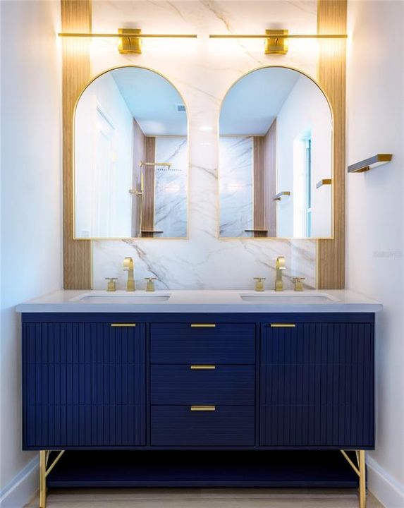 The navy blue Vanity in the primary ensuite adds a touch of sophistication, creating a luxury-style atmosphere.