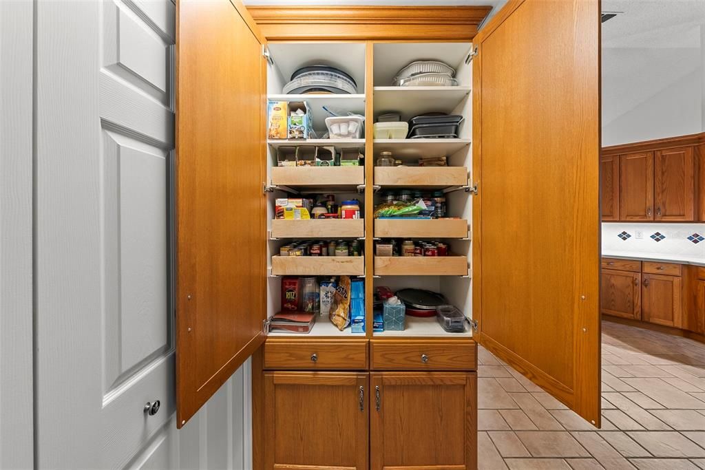 View of unique custom-designed pantry with TONS of storage, pull-out drawers, built-in ironing board and more!