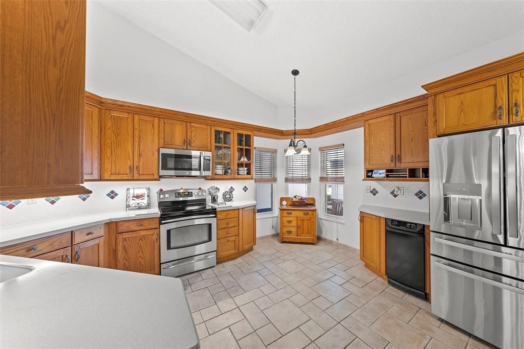 Large custom- designed eat-in kitchen with wood cabinetry, stainless steel appl. sep. coffee station, drawers/doors, pot/pan drawer, under cabinet lighting and more!