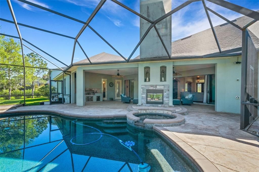 The pool patio area, features a pebble tech salt water pool, spa, wood burning fire place , outdoor shower, pool bath access , along with el fresco patio dining , outdoor living room and kitchen.