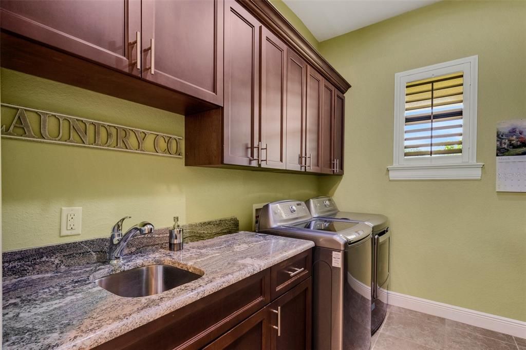 The Laundry room has plenty of storage, laundry sink, folding/hanging space and a built-in ironing board...the washer & dryer convey with the property.