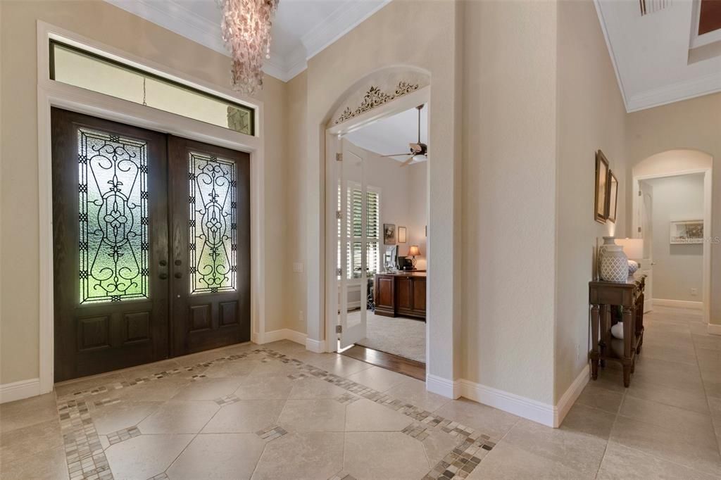 As you enter the foyer , you're greeted by soaring ceilings ,extensive crown molding and custom double front doors, & the entrance to the designated office.