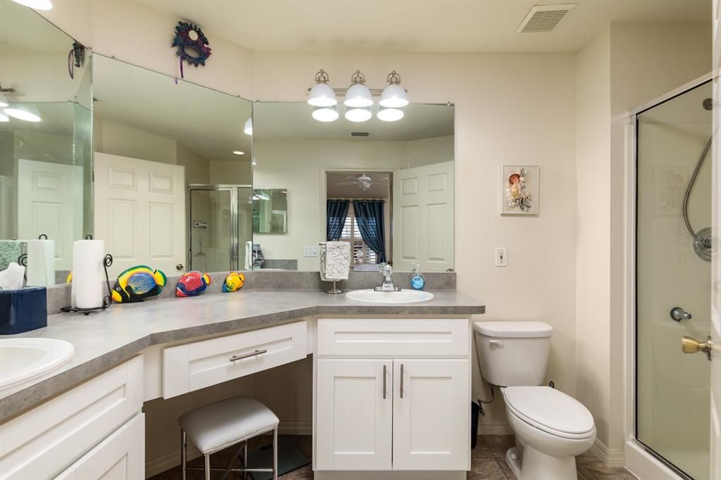 En-suite bathroom w/makeup vanity desk, 2 sinks & a shower. Exhaust vent.